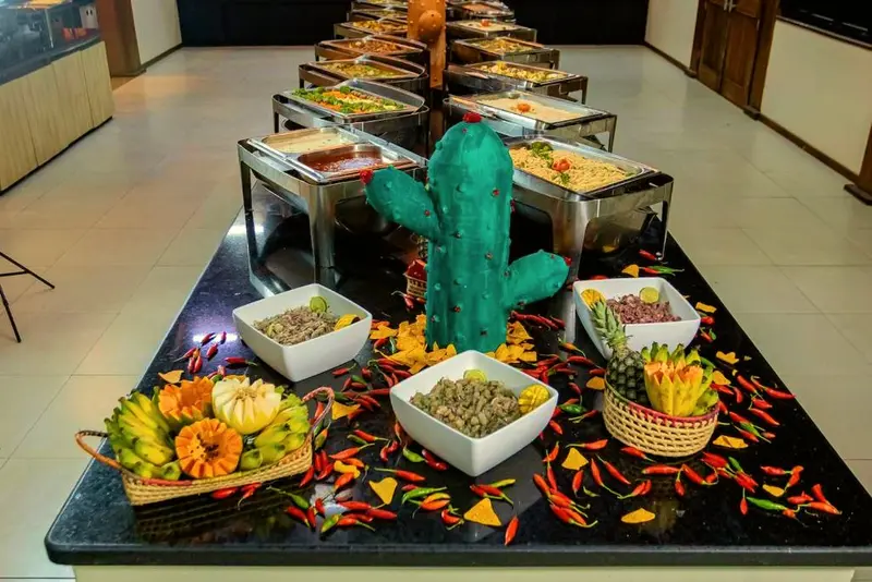 Mesa de bufê decorada com cacto, tigelas de saladas e pimentas coloridas