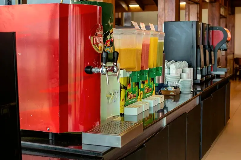 Estação de bebidas com chopeira, sucos e máquina de café no restaurante