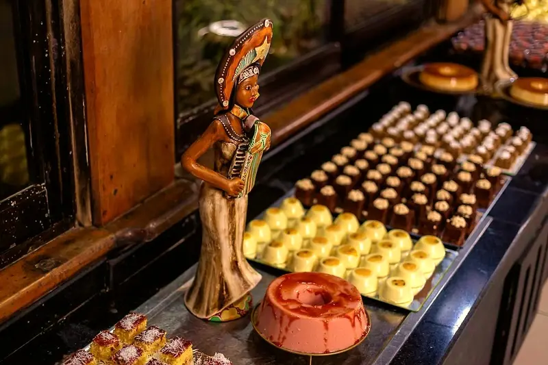Bandejas de doces e sobremesas no bufê, com escultura decorativa