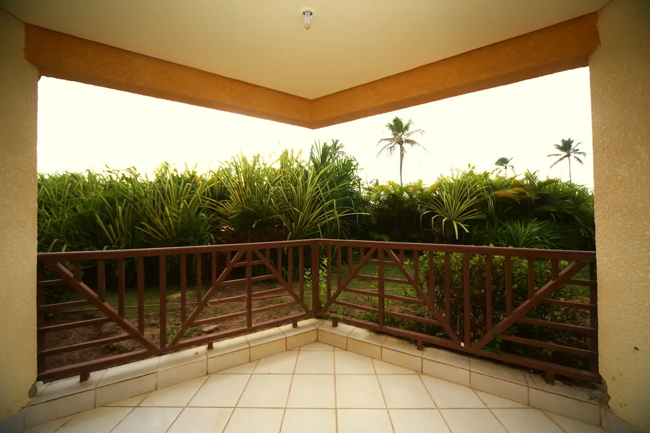 Varanda do apartamento Superior com guarda-corpo de madeira e vista para o jardim