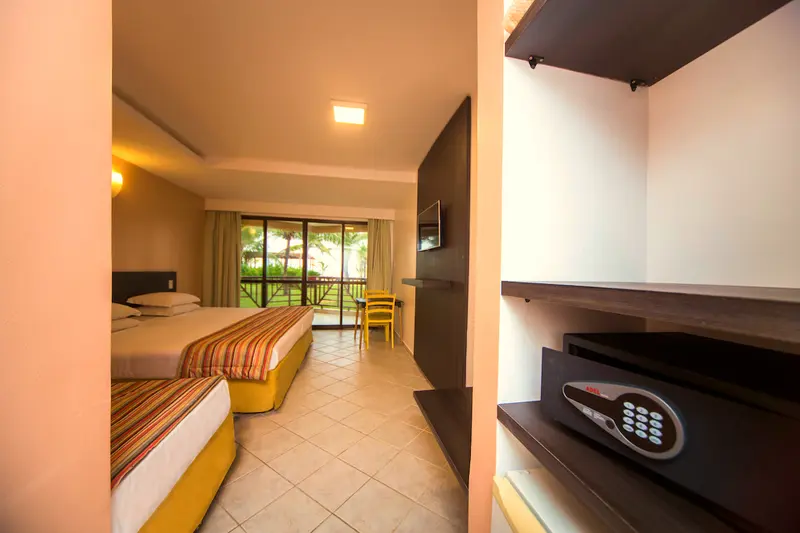 Apartamento Superior Vista Mar com cofre eletrônico, prateleiras e a cama ao fundo
